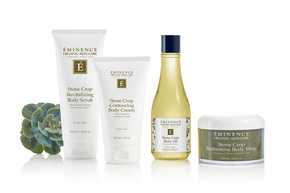 Five Éminence organic skincare products displayed alongside a green succulent.