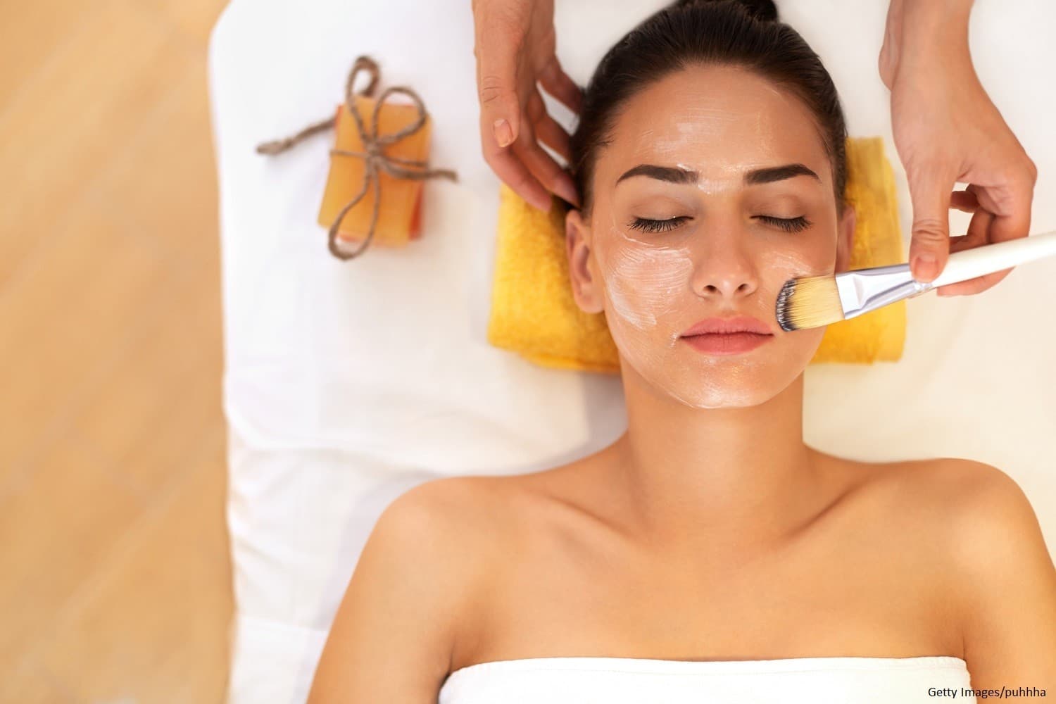 A woman receiving a facial treatment in a spa setting. A woman receiving a facial treatment in a spa setting.