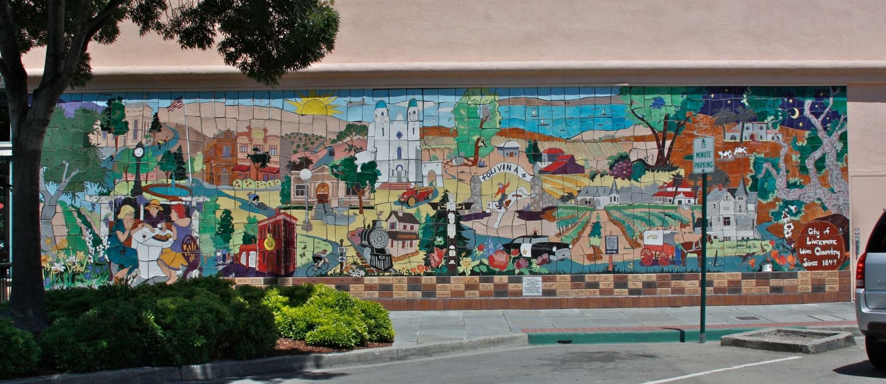 A vibrant mural depicting various scenes of rural life and landscapes, featuring a mix of flora, fauna, and historic buildings. A vibrant mural depicting various scenes of rural life and landscapes, featuring a mix of flora, fauna, and historic buildings.