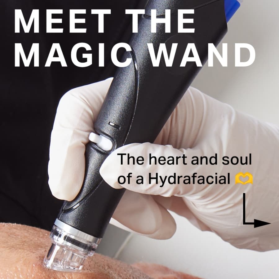 Close-up of a hand holding a handheld device used in a Hydrafacial treatment.