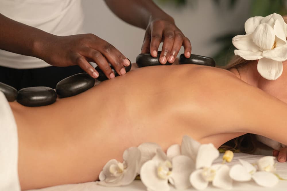 Woman on spa table with hot rocks