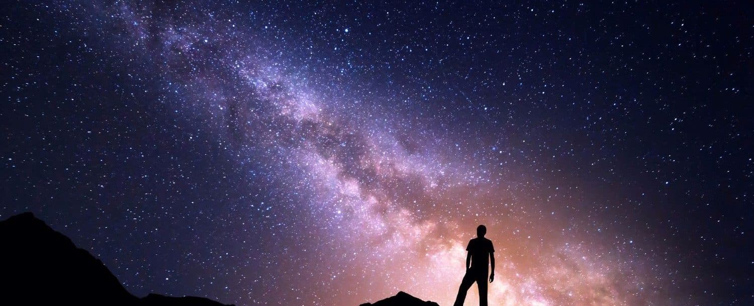 Silhouette of a person standing before a starry night sky with the Milky Way. Silhouette of a person standing before a starry night sky with the Milky Way.
